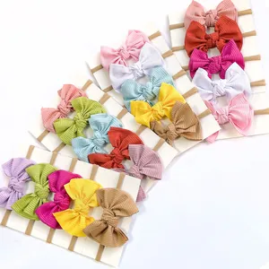 Set of baby nylon headbands with large ribbed fabric bows in multiple candy colors