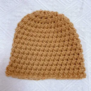Hand-knitted warm baby winter hat in camel color with thick thermal yarn texture