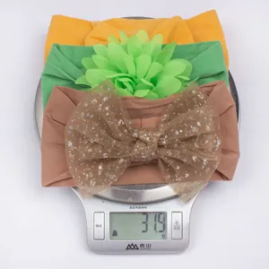 Balance numérique affichant le poids de 31,9g pour le lot de trois bandeaux bébé