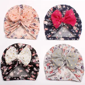 Detail showing baby turbans in four colors with floral print and large sequined mesh bows