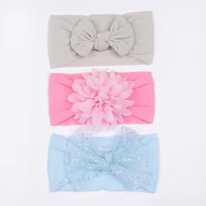 Détail de 3 bandeaux pour bébé en nylon avec nœuds, fleurs et finitions pailletées