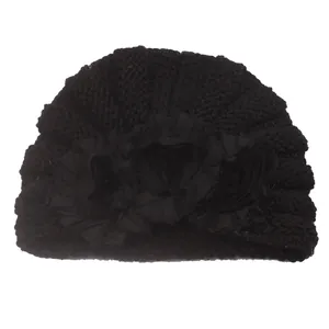 Close-up of winter knitted baby turban hat featuring three large black fabric flowers