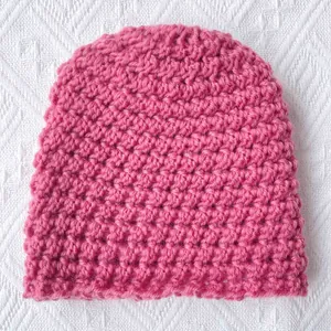 Handmade chunky knit winter beanie for babies in vibrant magenta with honeycomb texture