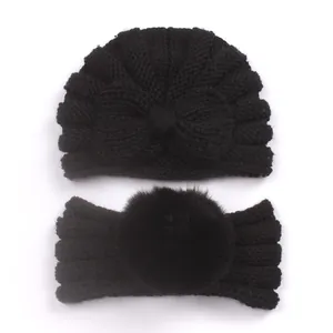 Detail of baby winter knit set with a bow hat and a faux fur pompom headband in black