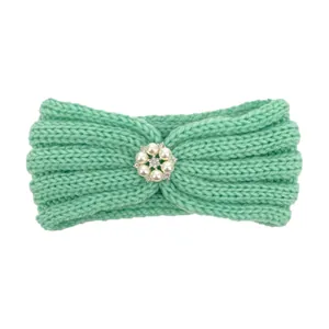 Detail of mint green knitted baby headband featuring a central pearl and rhinestone floral accent
