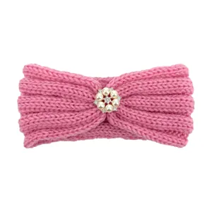 Detail of pink ribbed knit baby headband featuring a delicate six-pearl floral ornament