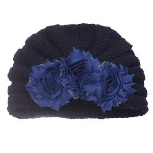 Detail of baby winter turban hat with 3D navy fabric roses and soft knit texture