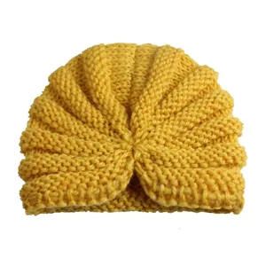 Felgele gebreide babymuts met decoratieve knoop en zachte ribgebreide textuur voor baby's