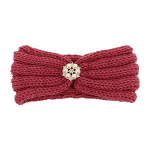 Detail of dark red knitted baby headband with a pearl and rhinestone flower accent