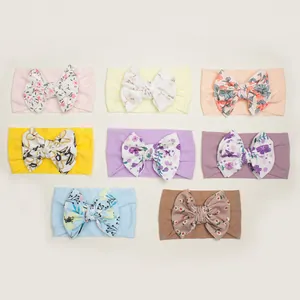 Set of eight assorted floral print and solid bow headbands for baby girls in pastel colors