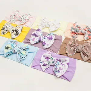 Flat lay of baby headbands with large textured bows in various colors and floral patterns