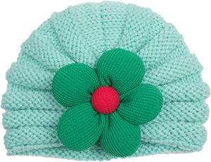 Dettaglio ravvicinato del turbante in maglia verde menta per neonati con grande fiore