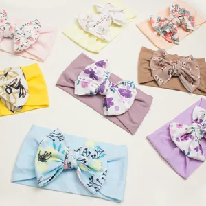 Close-up of seven assorted baby bow headbands with floral patterns and ribbed texture