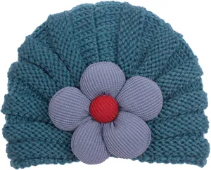 Dettaglio cappello in maglia blu scuro con grande fiore viola e trama a spirale spessa
