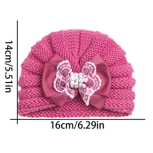 Detail of rose pink baby knit hat with lace bow and pearls showing 14x16cm dimensions