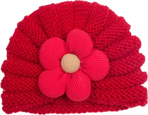 Dettaglio del cappello in maglia rossa per neonati con grande fiore decorativo
