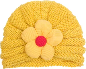 Dettaglio del cappello a turbante giallo per neonati con un grande fiore in tessuto morbido