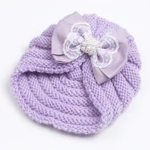 Knit baby beanie in light purple featuring a large lace bow and pearl embellishments