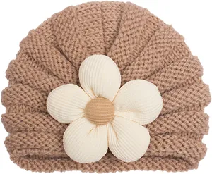 Trama in maglia dettagliata di un berretto per neonati con grande fiore 3D beige