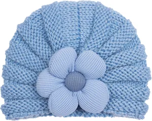 Dettaglio cappello neonato a maglia azzurro con grande fiore in tessuto a costine 3D