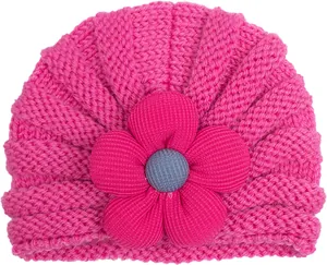 Dettaglio del cappello a turbante per neonati con un grande fiore in tessuto rosa