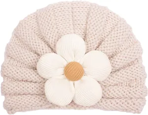 Dettaglio del cappello bimbo in maglia con grande fiore 3D e trama beige morbida