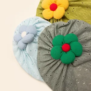 Detail of hollow embroidered baby turbans with 3D fabric flowers in various colors