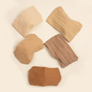 Detail of cable-knit baby headbands in five earthy colors with soft braided texture
