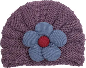 Dettaglio del turbante neonato viola a maglia con grande fiore blu e trama a costine spesse