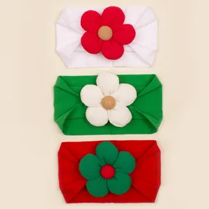 Detail of 3-pack baby Christmas headbands featuring large ribbed flower decorations