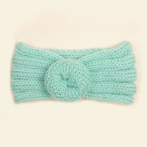 Détail d'un bandeau pour bébé en maille vert menthe avec motif donut et texture côtelée