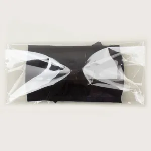 Gros plan d'un bandeau pour bébé en nylon noir emballé dans un sac en plastique transparent