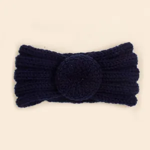 Gros plan sur bandeau bébé en maille bleu marine avec détail de nœud en tricot épais
