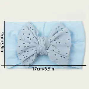 Détail d'un bandeau bébé bleu clair avec nœud ajouré et dimensions du produit précises