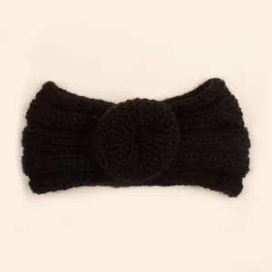 Détail d'un bandeau en maille noire pour bébé avec texture côtelée et nœud décoratif