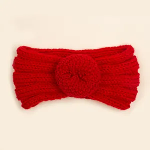 Détail macro du bandeau bébé en maille rouge avec nœud donut en laine côtelée