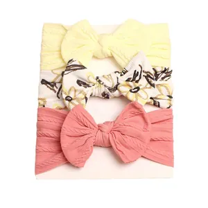 Set of 3 baby headbands with large bows in yellow, floral white, and dusty rose