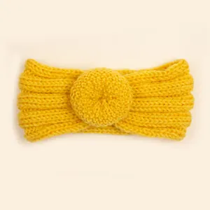 Vue macro du bandeau tricoté jaune gingembre avec détail de nœud donut et texture côtelée