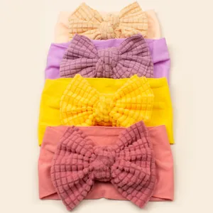 Detail of four waffle texture baby headbands with large bows in pastel spring colors
