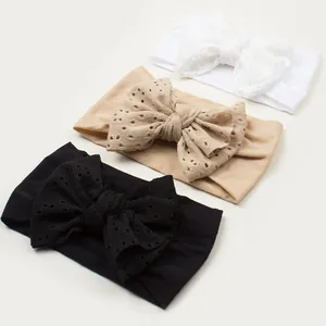 Détail de trois bandeaux bébé en nylon souple avec nœuds à broderie ajourée