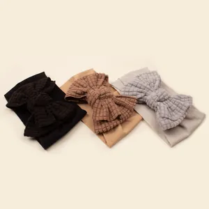 Three-pack of waffle knit baby headbands with large bows in black, brown, and grey colors