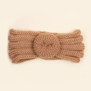 Détail d'un bandeau en maille côtelée camel pour bébé avec décoration de beignet