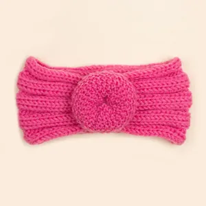 Détail d'un bandeau en maille rose pour bébé avec motif donut 3D et texture côtelée