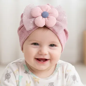 Detail of pink baby turban hat featuring a large 3D flower and glittery mesh bow
