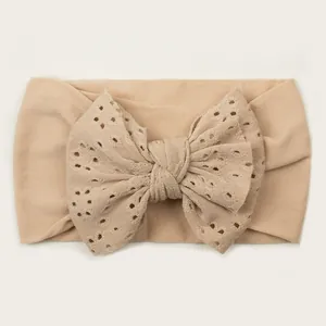 Bandeau bébé en nylon souple avec un grand nœud ajouré de couleur beige naturel