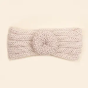 Détail macro du bandeau bébé en maille beige montrant la texture douce de la laine