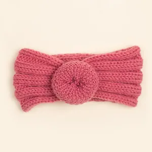 Détail d'un bandeau pour bébé en tricot rose avec un nœud en forme de donut doux