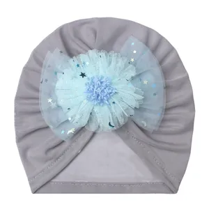 Detail of baby turban hat in grey fabric with a blue mesh flower and sequined stars