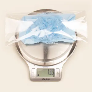 Lichtblauwe kanten baby hoofdband met gaasbloem op weegschaal met gewicht van 13,8 g