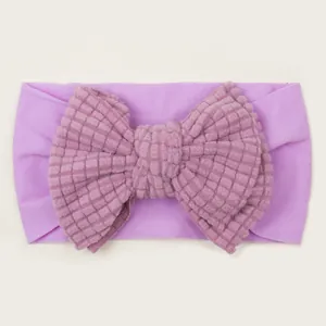 Detail of purple baby headband featuring a soft waffle texture oversized double bow